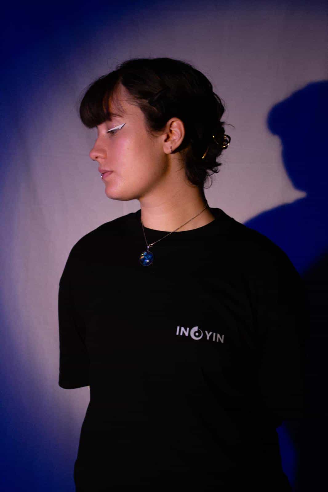 Ein Foto von Ino Yin und seinem Merch mit dem Motiv auf der Vorderseite und auf der Rückseite