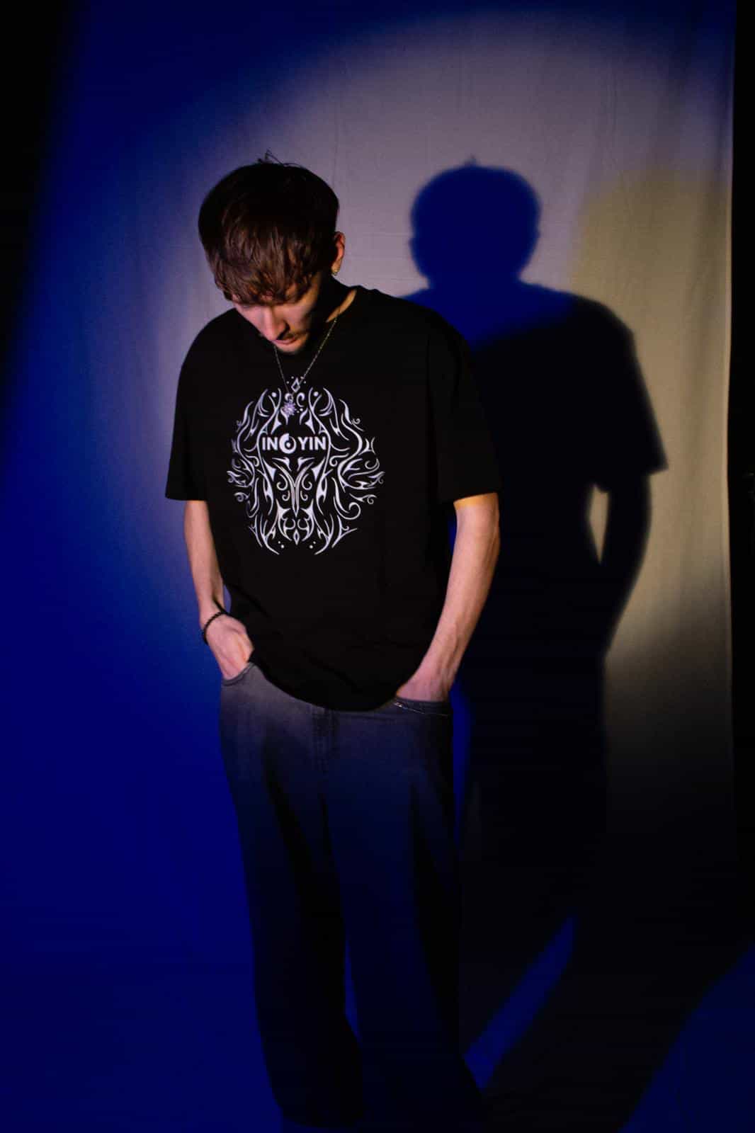 Ein Foto von Ino Yin und seinem Merch mit dem Motiv auf der Vorderseite und auf der Rückseite